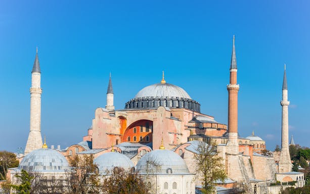 Hagia Sophia with minarets under clear blue sky in Istanbul.
