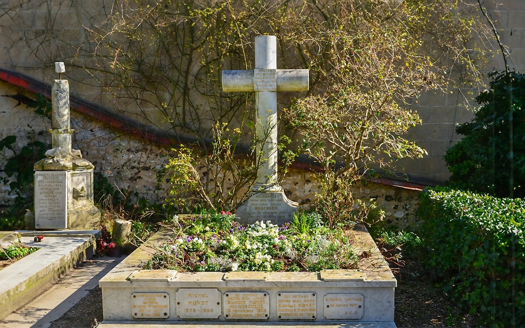 Grave of Claude Monet in Giverny, surrounded by flowers and greenery.