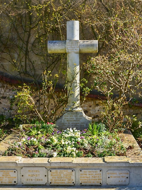 Grave of Claude Monet in Giverny, surrounded by flowers and greenery.