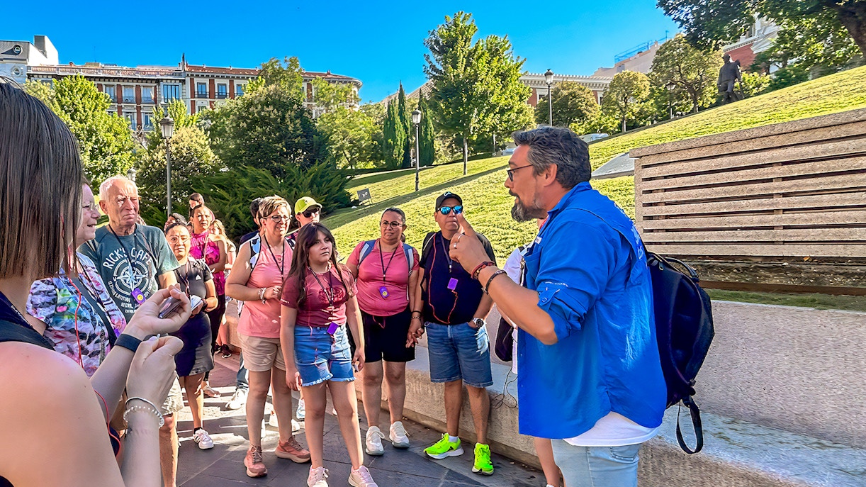 Visitors exploring art exhibits inside the Prado Museum, Madrid, during a guided tour.