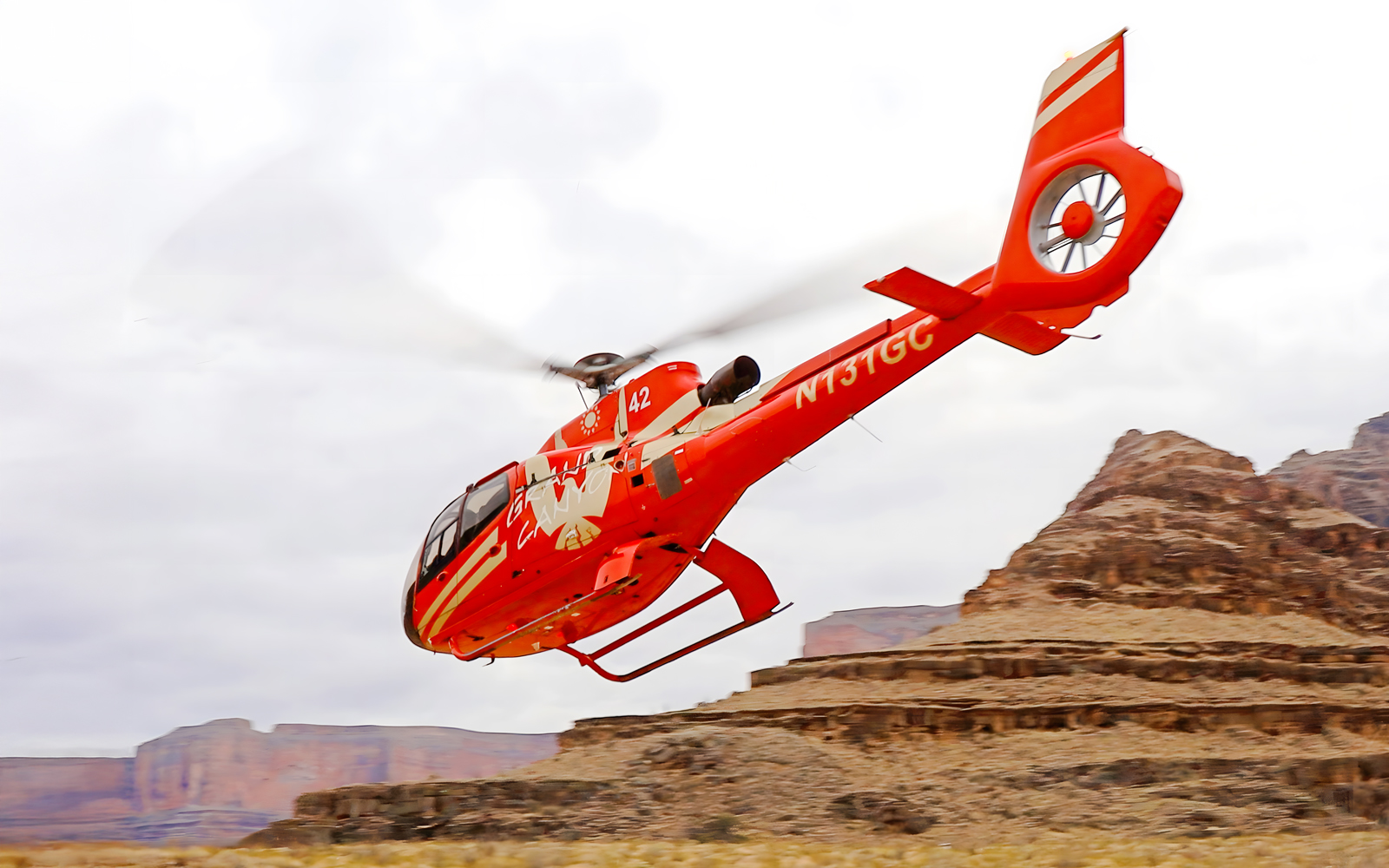 Helicopter flying over Grand Canyon West Rim during tour with floor landing and boat ride.