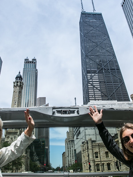 Tourists on an open-top bus enjoying the Chicago skyline during a Hop-On-Hop-Off tour.