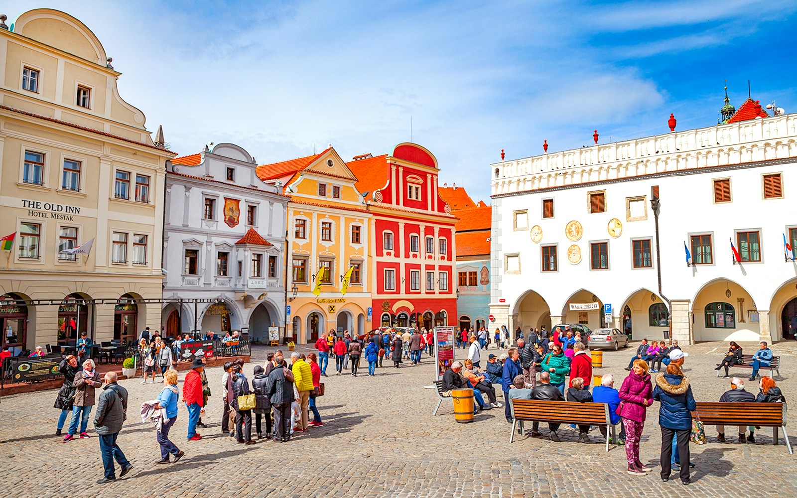 Cesky Krumlov main square with colorful historic buildings and tourists exploring.