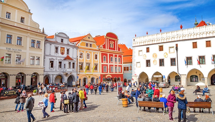 Cesky Krumlov main square with historic buildings and tourists exploring.