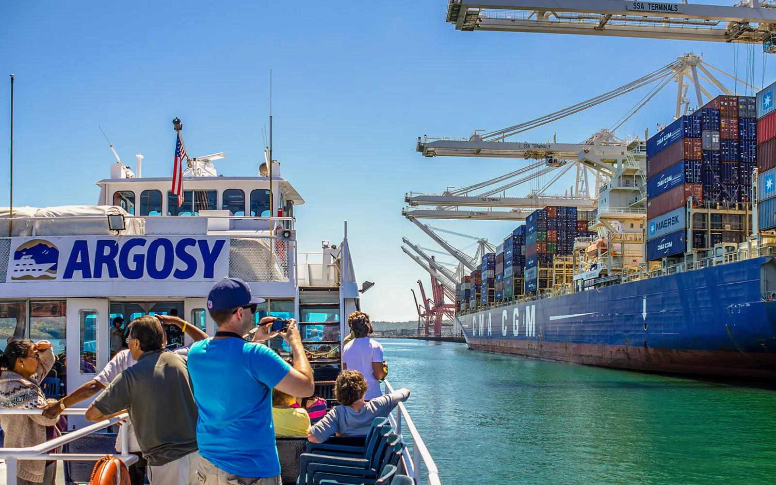 Tourists on Argosy cruise near container ship at Seattle port, part of Seattle CityPASS® experience.