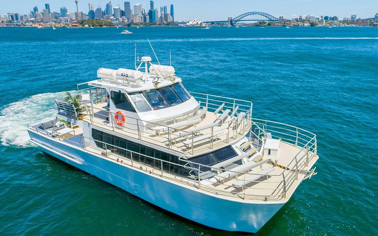 Cruise ship on Sydney Harbour with city skyline and Harbour Bridge in the background.