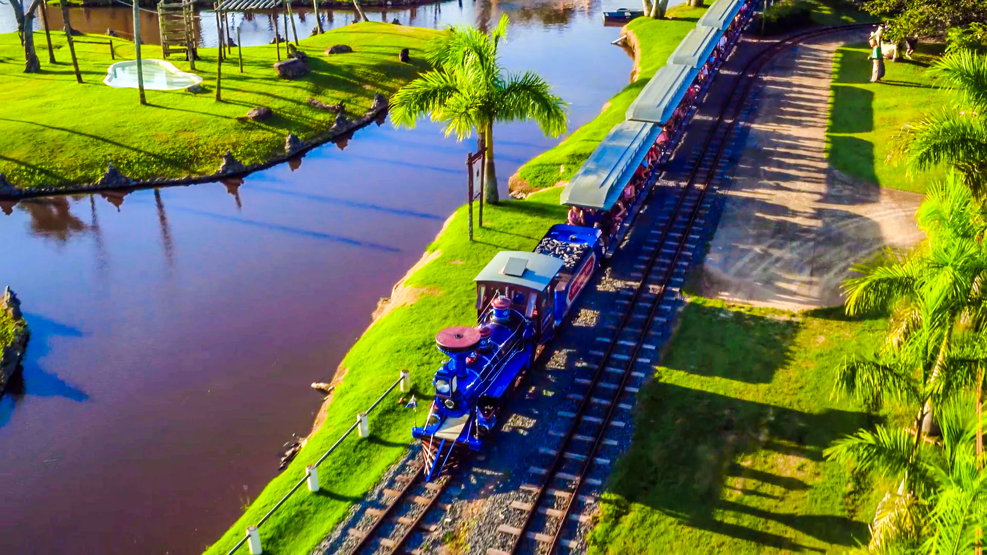 Train ride at Beto Carrero World, surrounded by lush greenery and water, Florianópolis transfer.