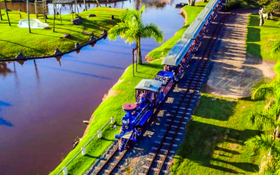 Train ride at Beto Carrero World, surrounded by lush greenery and water, Florianópolis transfer.