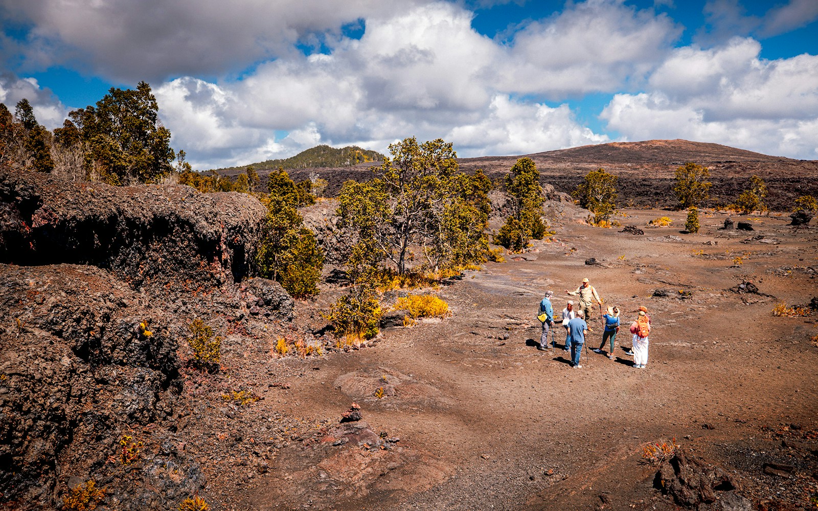 Group exploring volcanic landscape on Hawaii adventure tour.