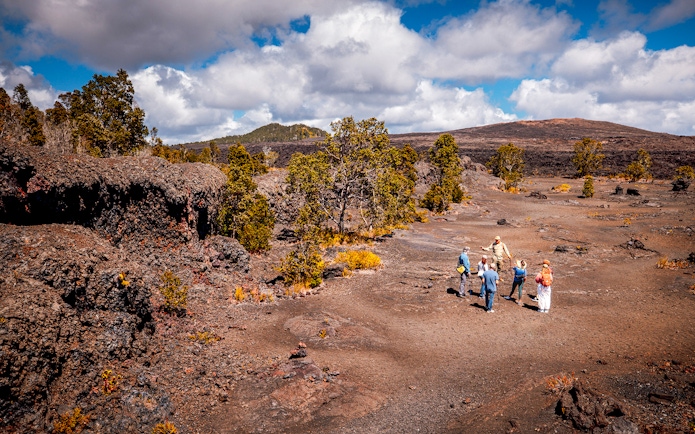 Group exploring volcanic landscape on Hawaii adventure tour.