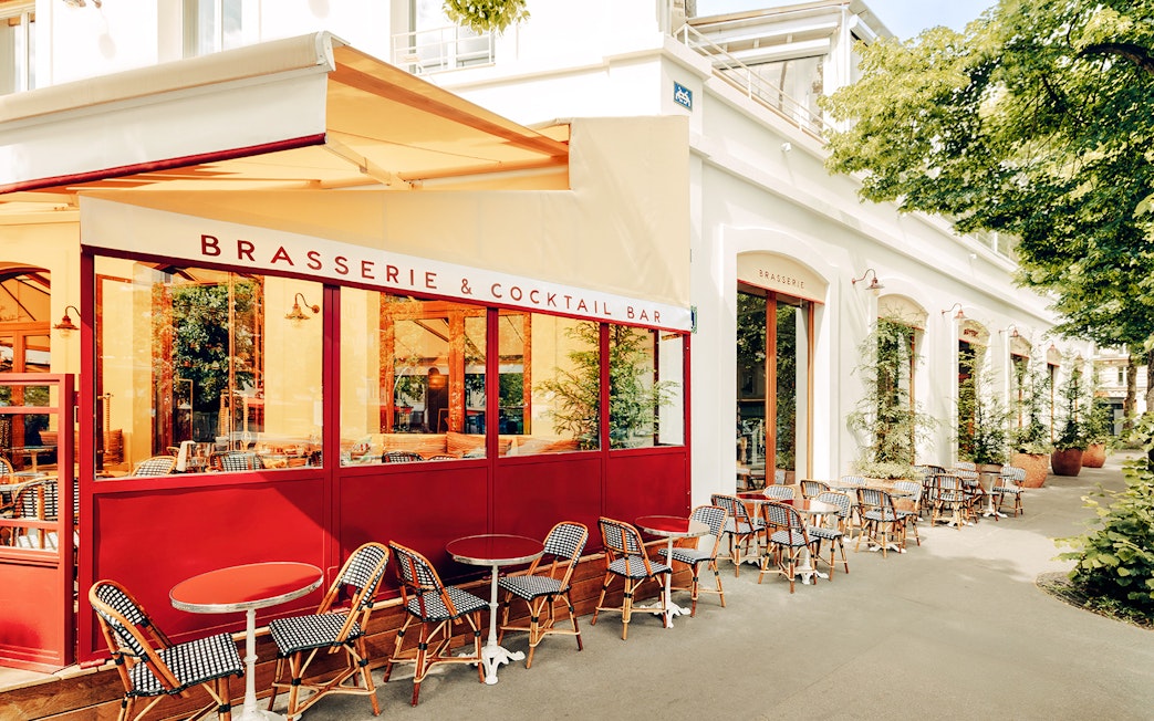 Brasserie Auteuil exterior with outdoor seating and red accents in Paris.