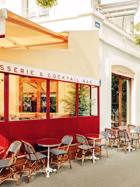 Brasserie Auteuil exterior with outdoor seating and red accents in Paris.