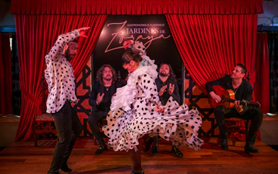 Flamenco dancers performing at Tablao Jardines de Zoraya with musicians in the background.