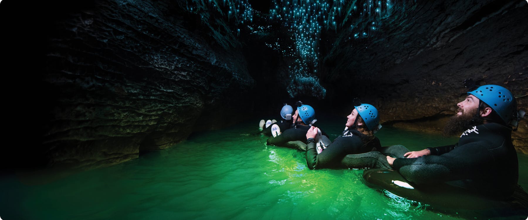 Visitors exploring Waitomo Glowworm Caves by raft, New Zealand.