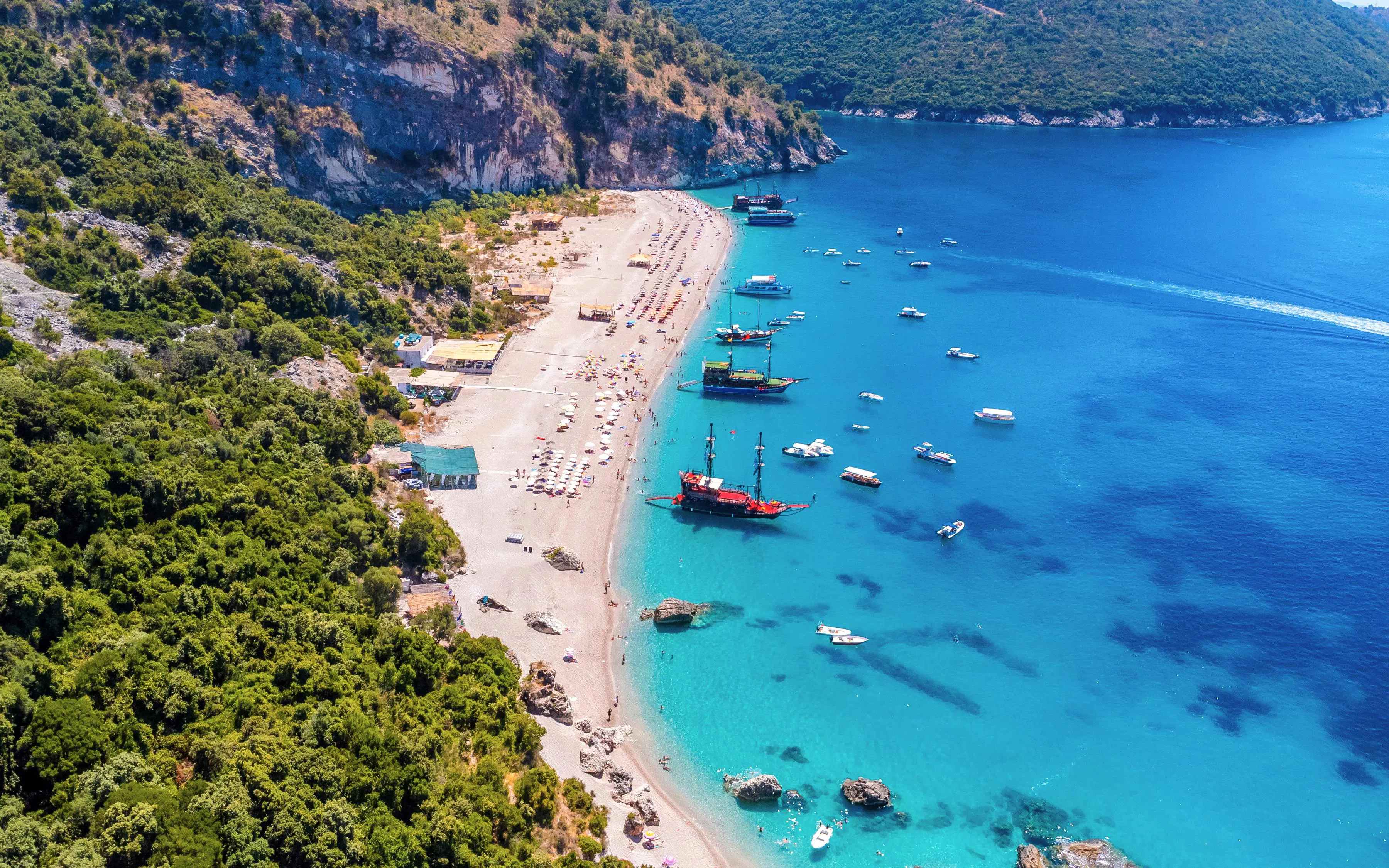 Aerial view of Krorez Beach with boats and coastline in Sarande, Albania.