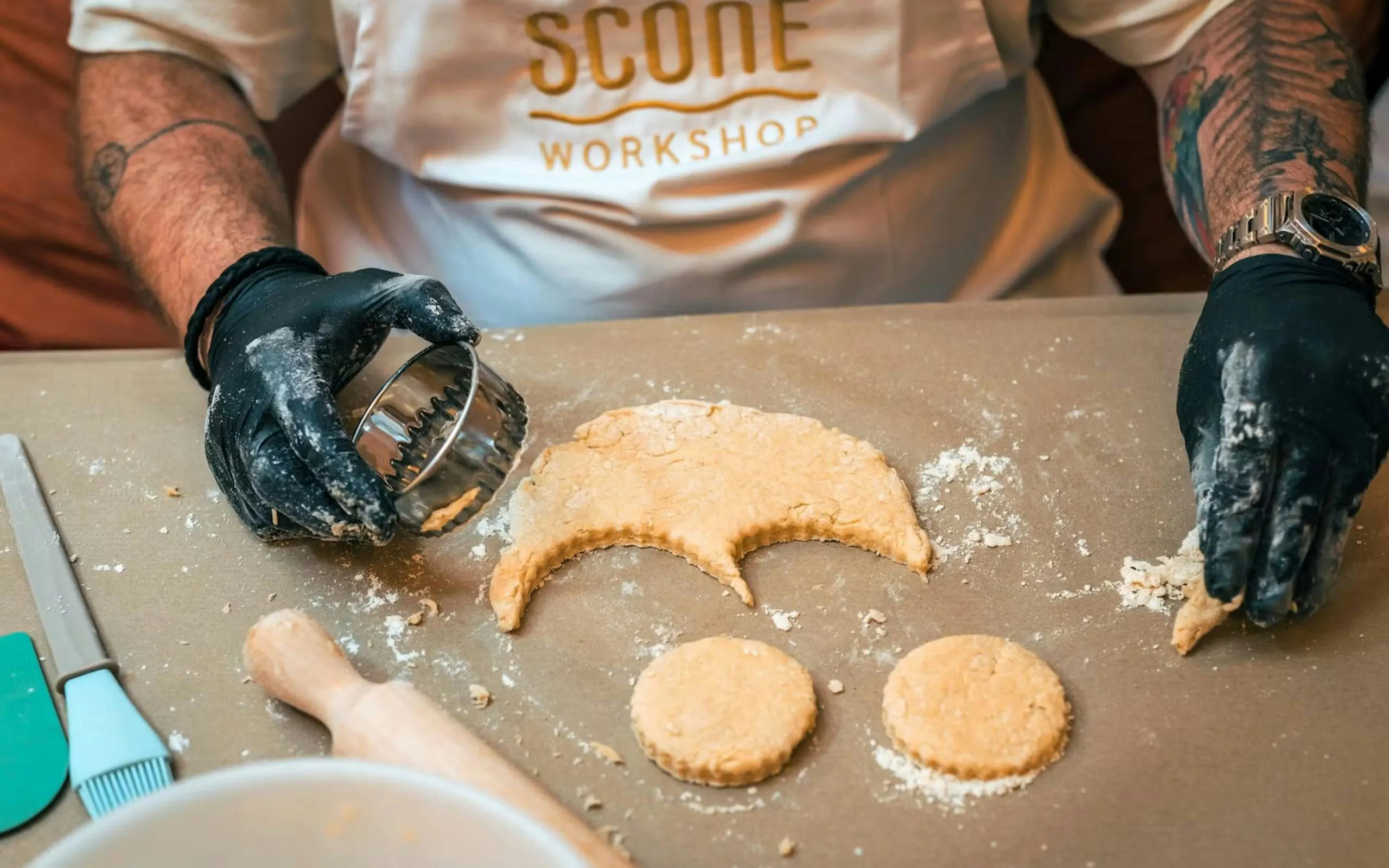 Scone dough being cut with a round cutter during a workshop in London.