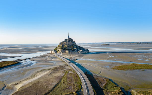 Aerial view of Mont Saint-Michel with connecting bridge, Normandy, France.