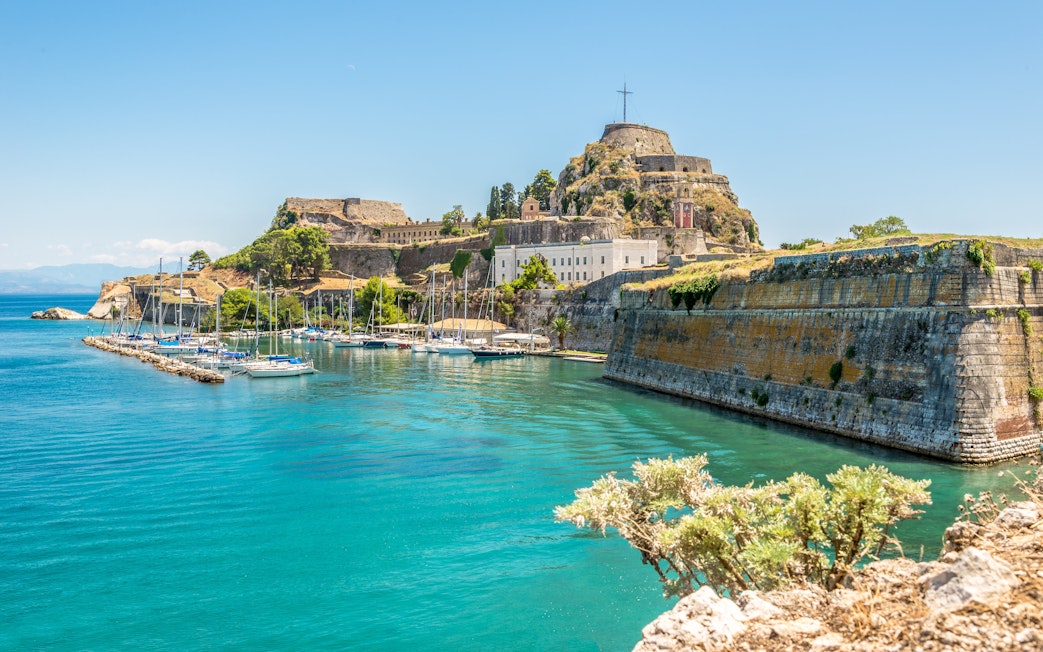The Old Fortress of Corfu with yachts docked in the surrounding blue waters.