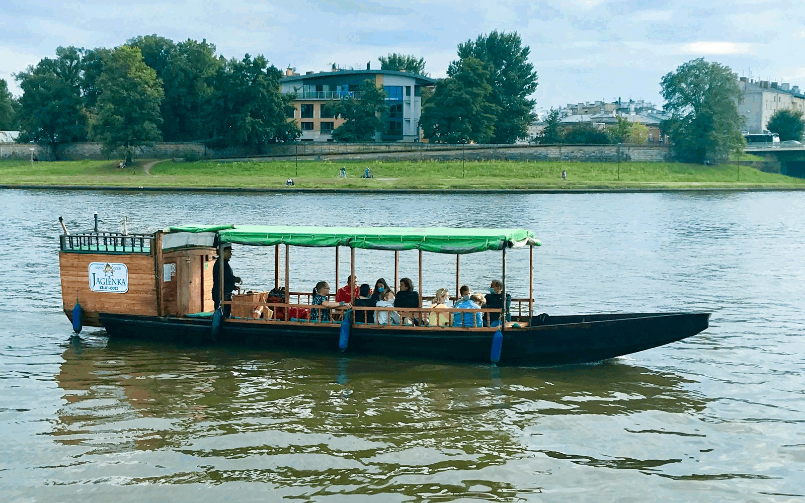 Tourists on a wooden boat during a 1-hour morning cruise on the Vistula River, Krakow.