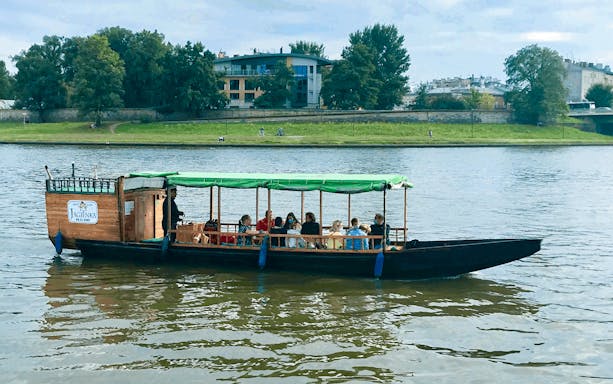 Tourists on a wooden boat during a 1-hour morning cruise on the Vistula River, Krakow.