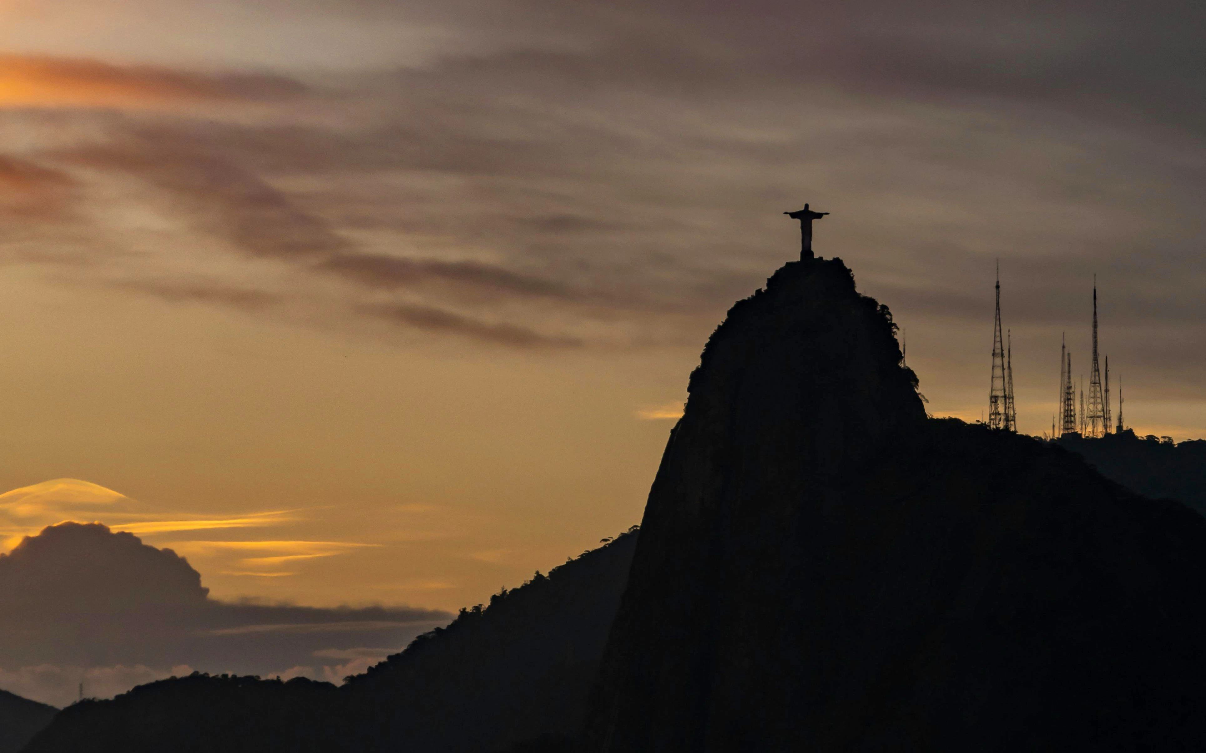 Silhouette of Christ the Redeemer statue on Corcovado Mountain at sunset, Rio de Janeiro.