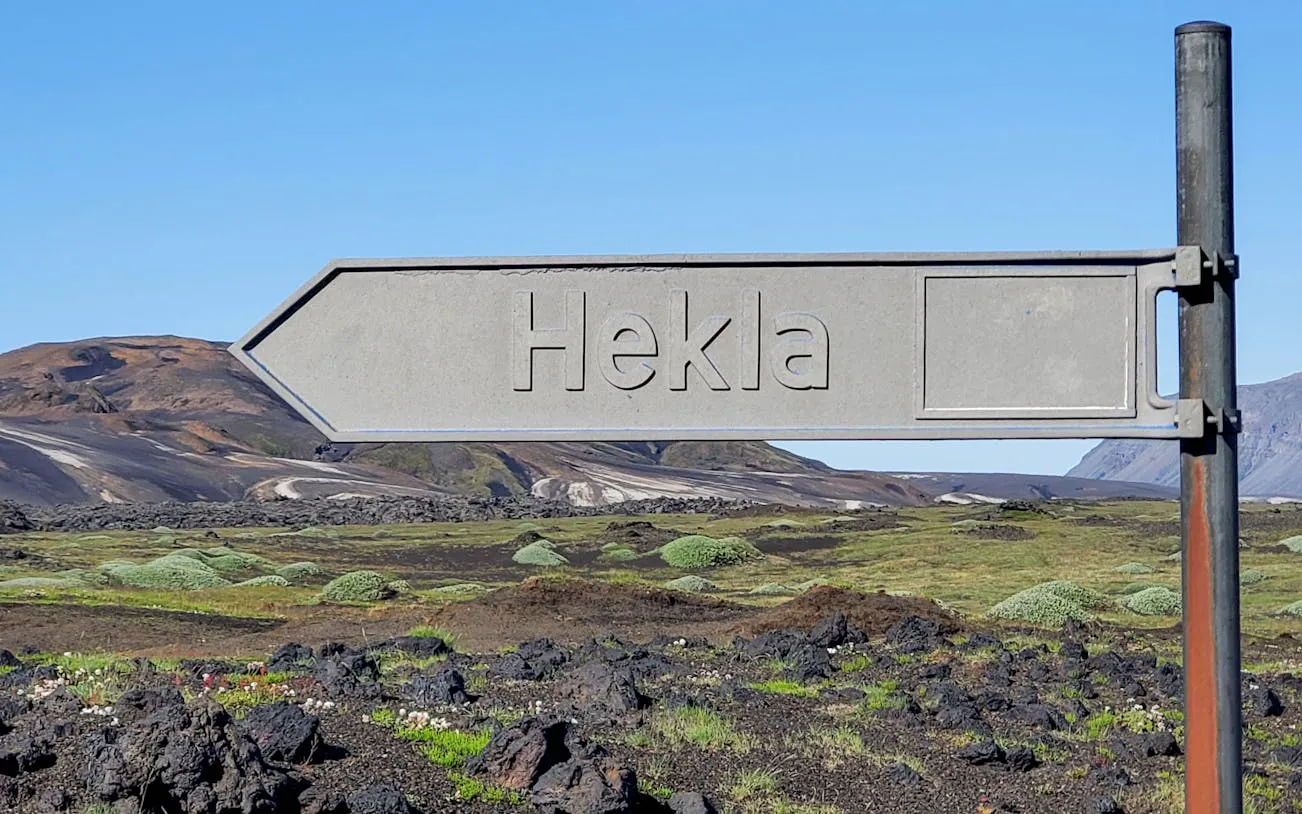 Hekla signpost in Landmannalaugar Highlands, Iceland, with volcanic landscape in background.