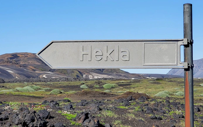 Hekla signpost in Landmannalaugar Highlands, Iceland, with volcanic landscape in background.