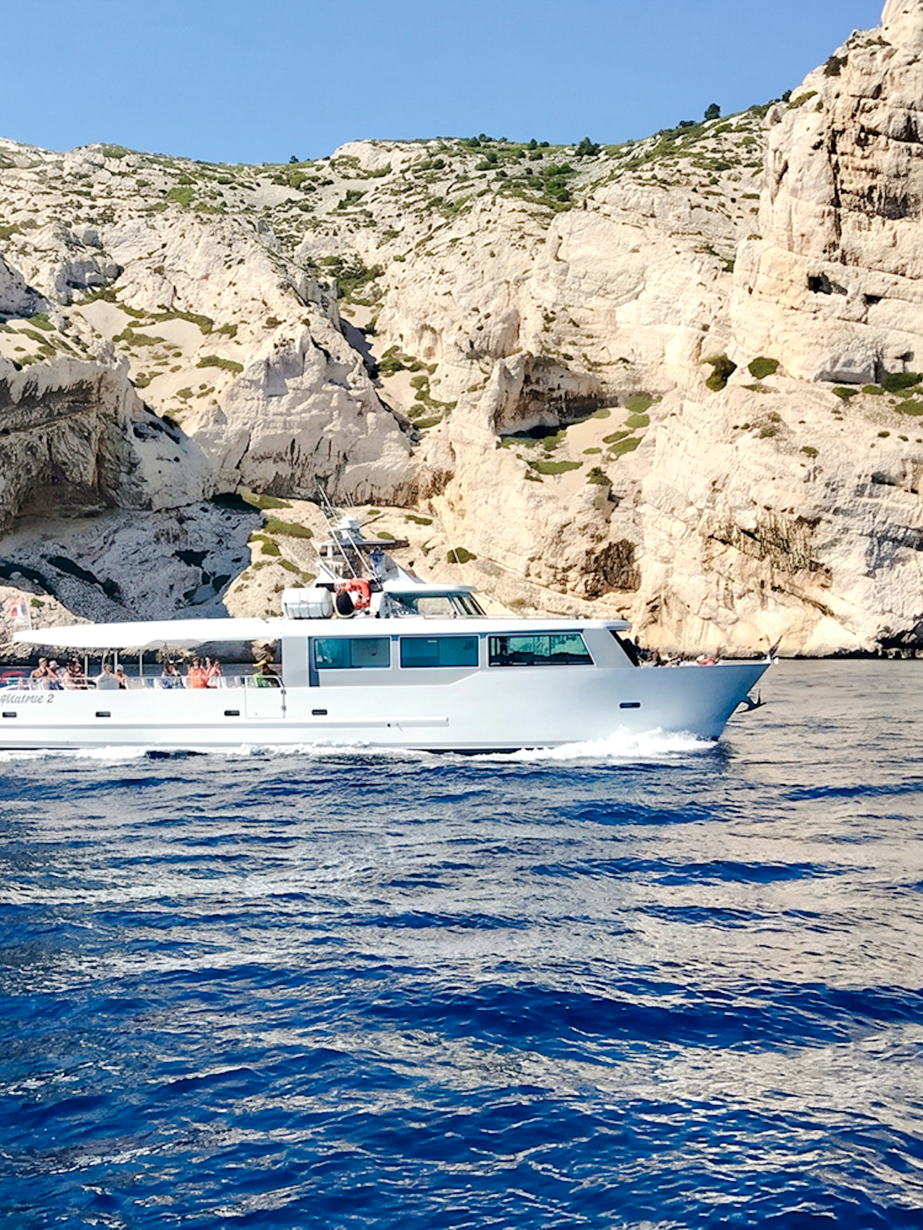 Boat cruising along rocky coastline during Monaco boat tour.