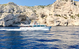 Boat cruising along rocky coastline during Monaco boat tour.