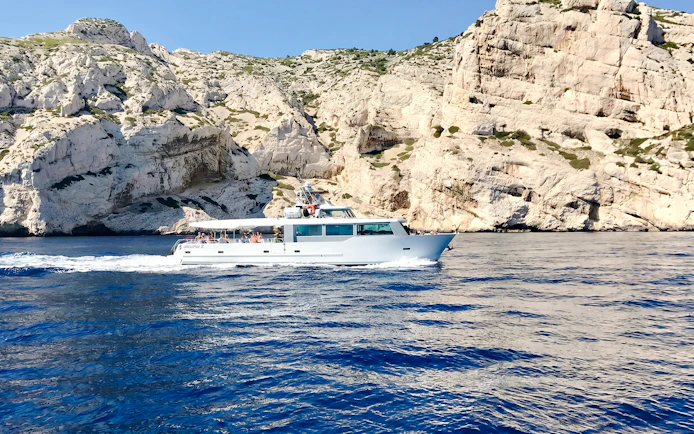 Boat cruising along rocky coastline during Monaco boat tour.