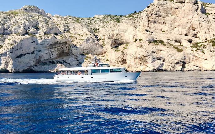 Boat cruising along rocky coastline during Monaco boat tour.