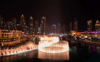 Dubai Fountain show at night with city skyline, viewed from Big Bus Dubai Night Tour.