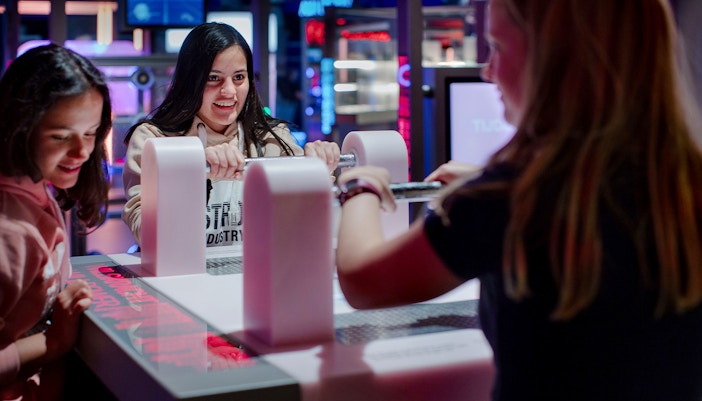 Visitors engaging with interactive exhibit at NEMO Science Museum, Amsterdam.