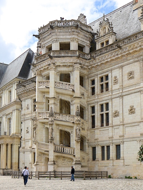 Royal Blois Castle exterior with visitors in courtyard, France.