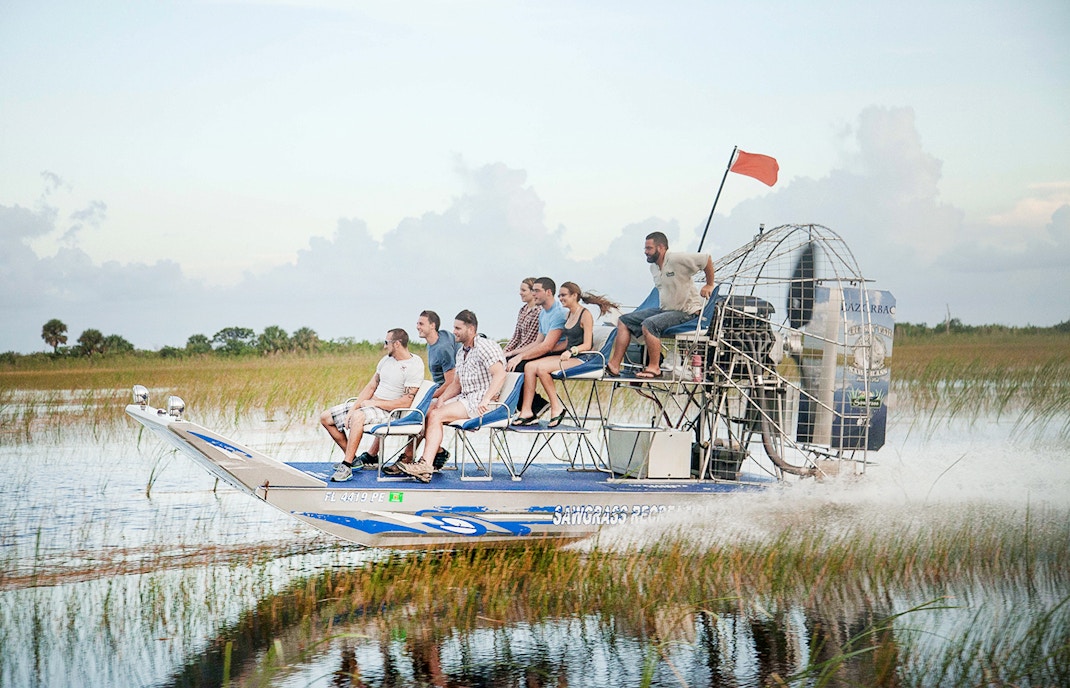 Airboat gliding through Everglades wetlands during private 1-hour adventure tour in Miami.