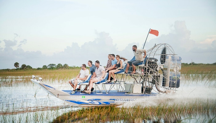 Airboat gliding through Everglades wetlands during private 1-hour adventure tour in Miami.