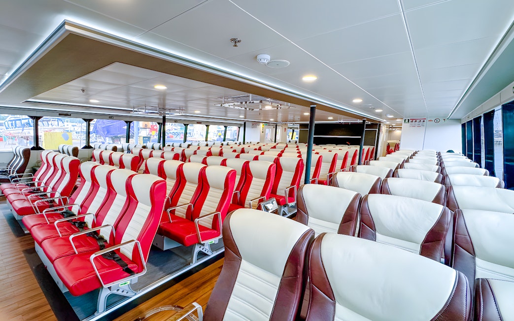 Ferry interior with rows of red and white seats, Singapore to Batam route.