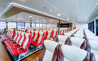 Ferry interior with rows of red and white seats, Singapore to Batam route.