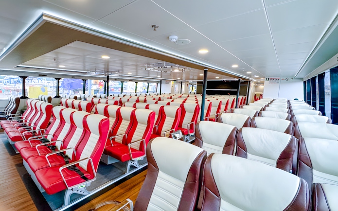 Ferry interior with rows of red and white seats, Singapore to Batam route.