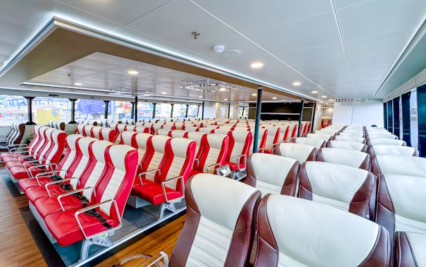 Ferry interior with rows of red and white seats, Singapore to Batam route.