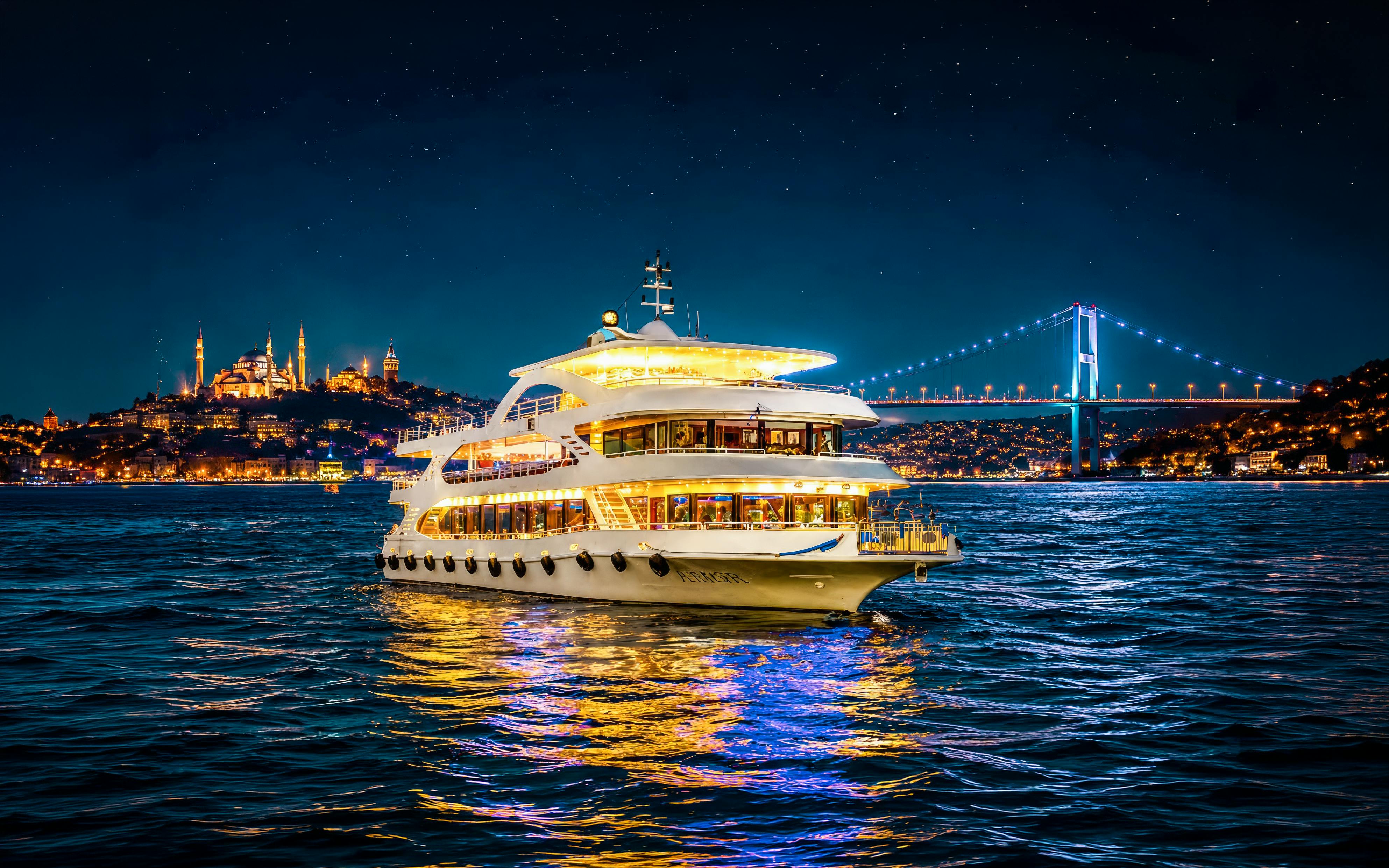 Cruise ship on Bosphorus strait at night with illuminated bridge and cityscape.