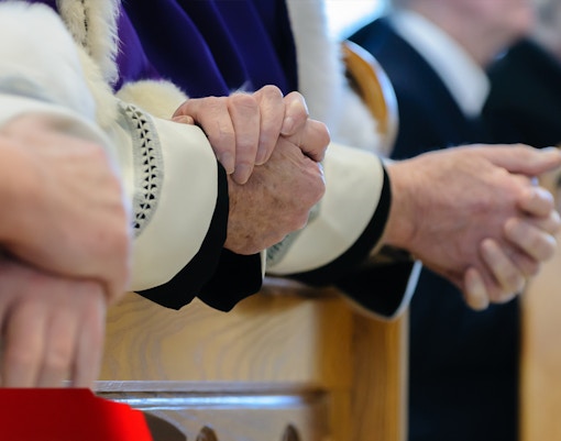 Priests conducting a ceremonial prayer in a church during mass.