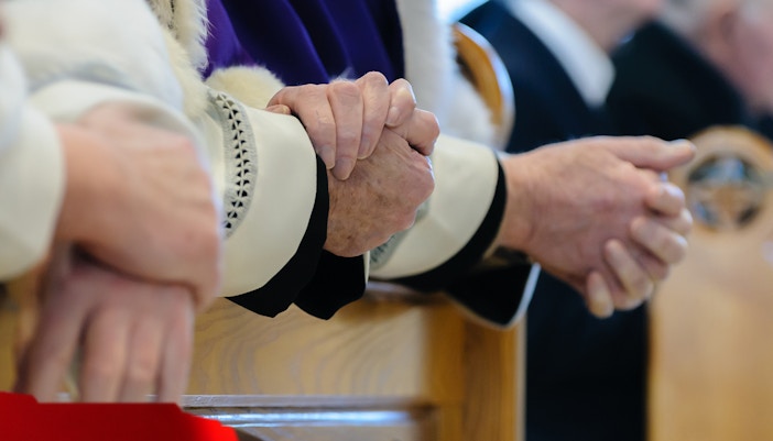 Priests conducting a ceremonial prayer in a church during mass.