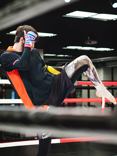 Muay Thai fighter practicing a kick in a gym ring.