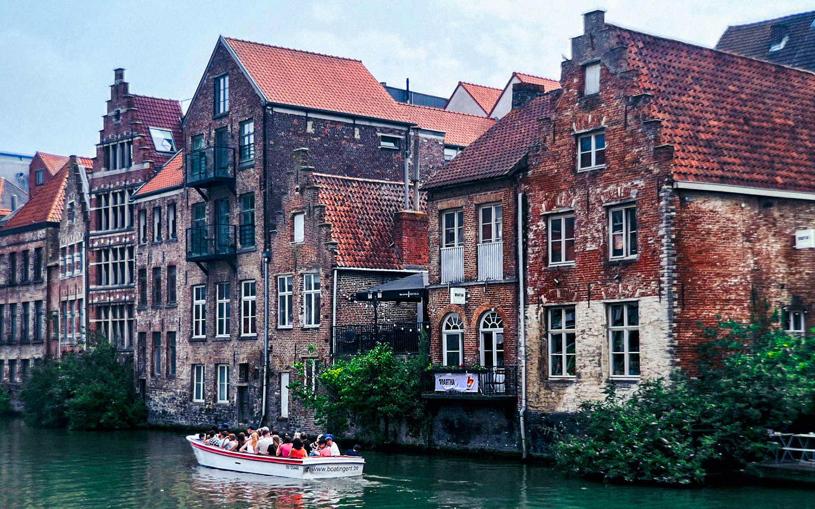 Boat tour along historic canal buildings in Ghent, Belgium.