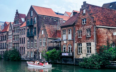 Boat tour along historic canal buildings in Ghent, Belgium.