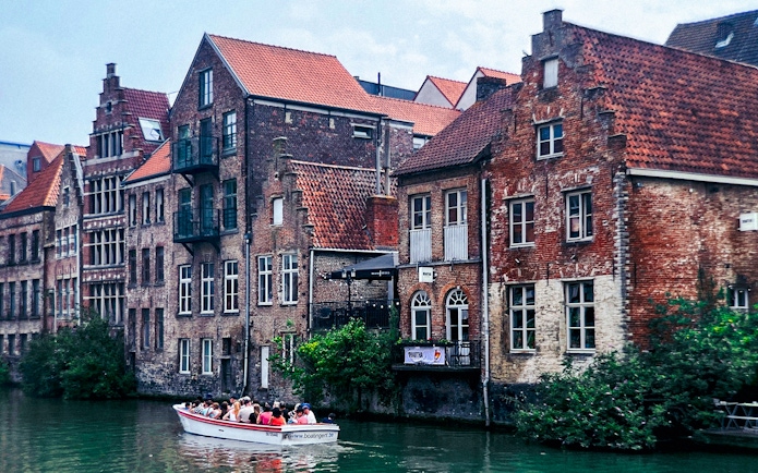 Boat tour along historic canal buildings in Ghent, Belgium.