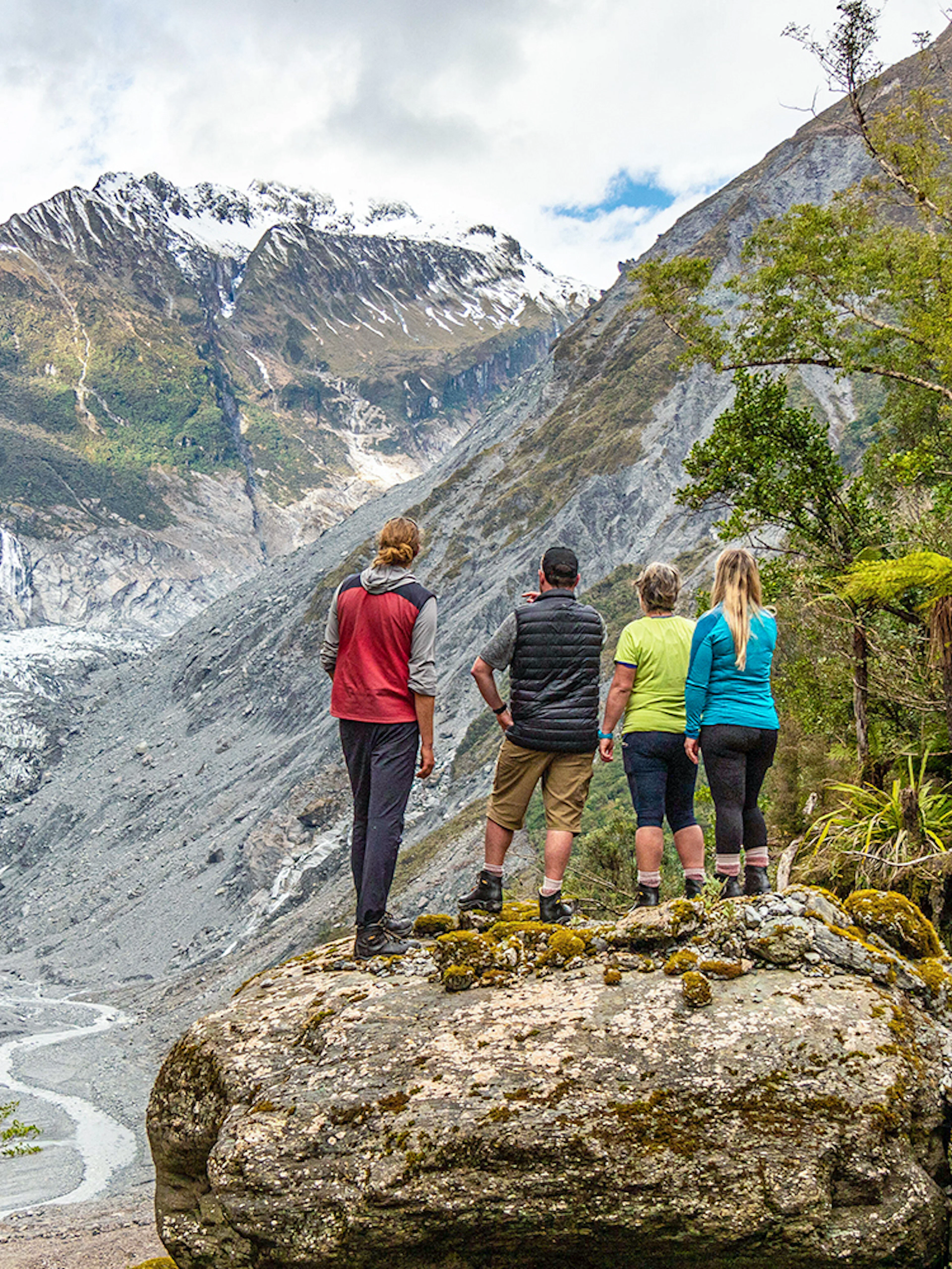 Tourists viewing Fox Glacier Valley landscape in New Zealand.