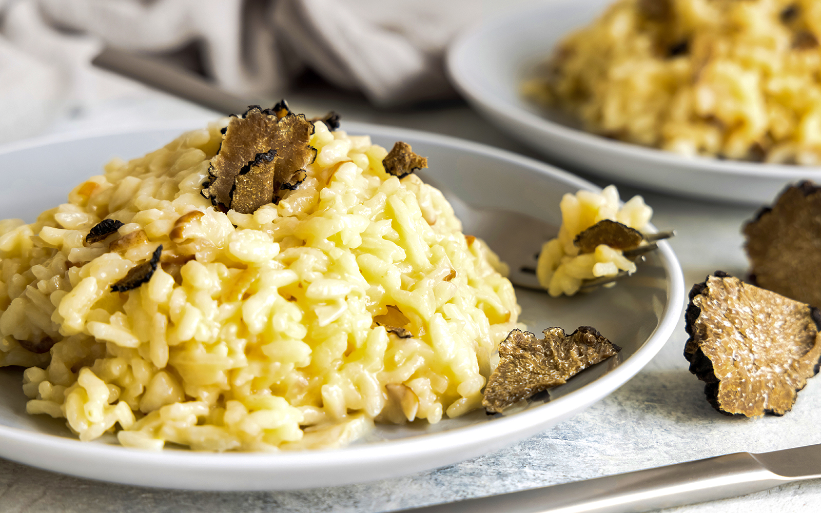 Truffle risotto served on a white plate at a gourmet restaurant in Madrid.