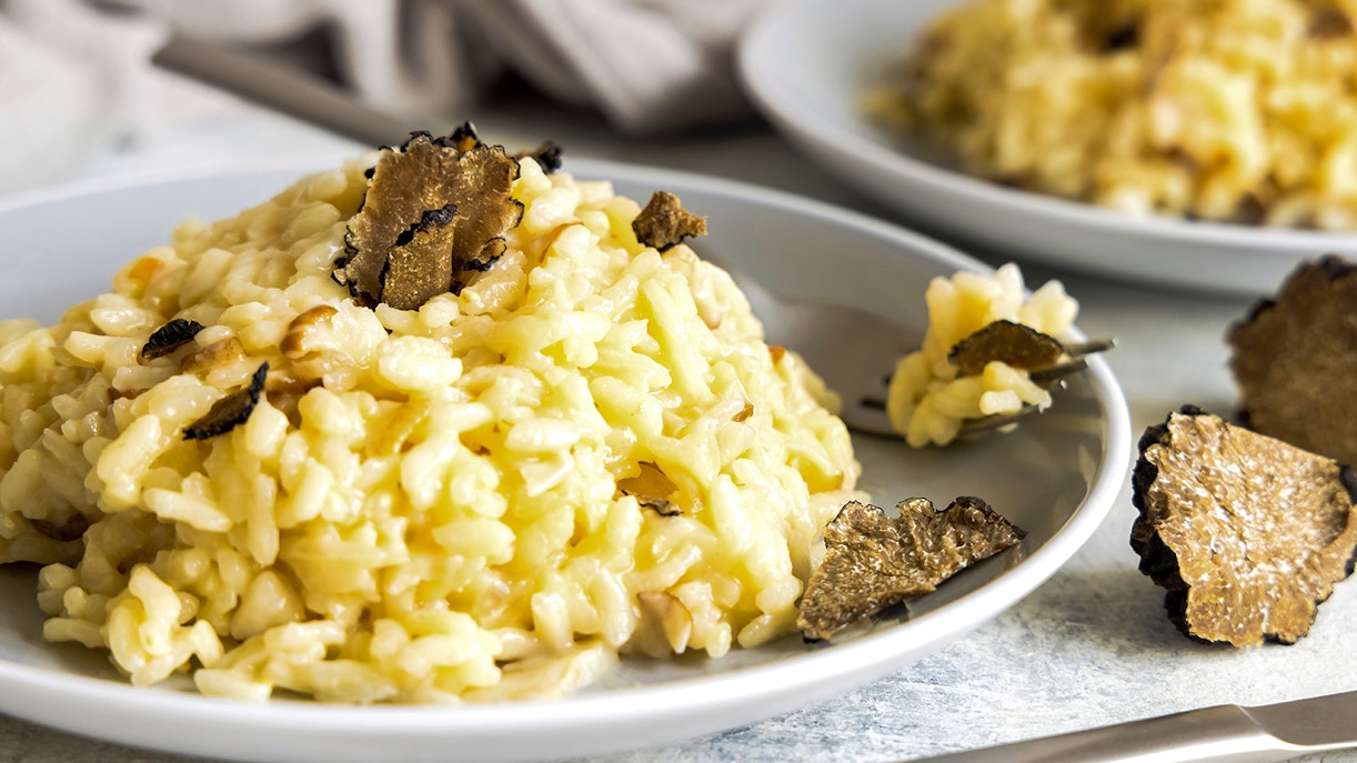 Truffle risotto served on a white plate at a gourmet restaurant in Madrid.